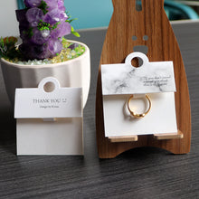 White ring display cards shown with rings in a boutique-style jewelry display