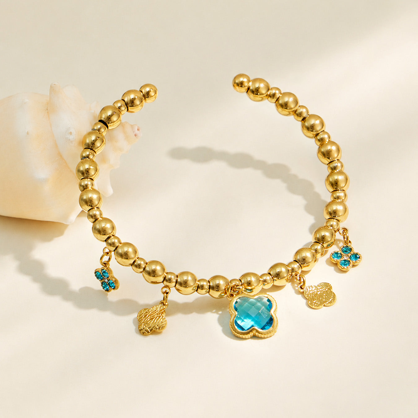 Blue four-leaf clover charm bracelet with small dangling clover accents