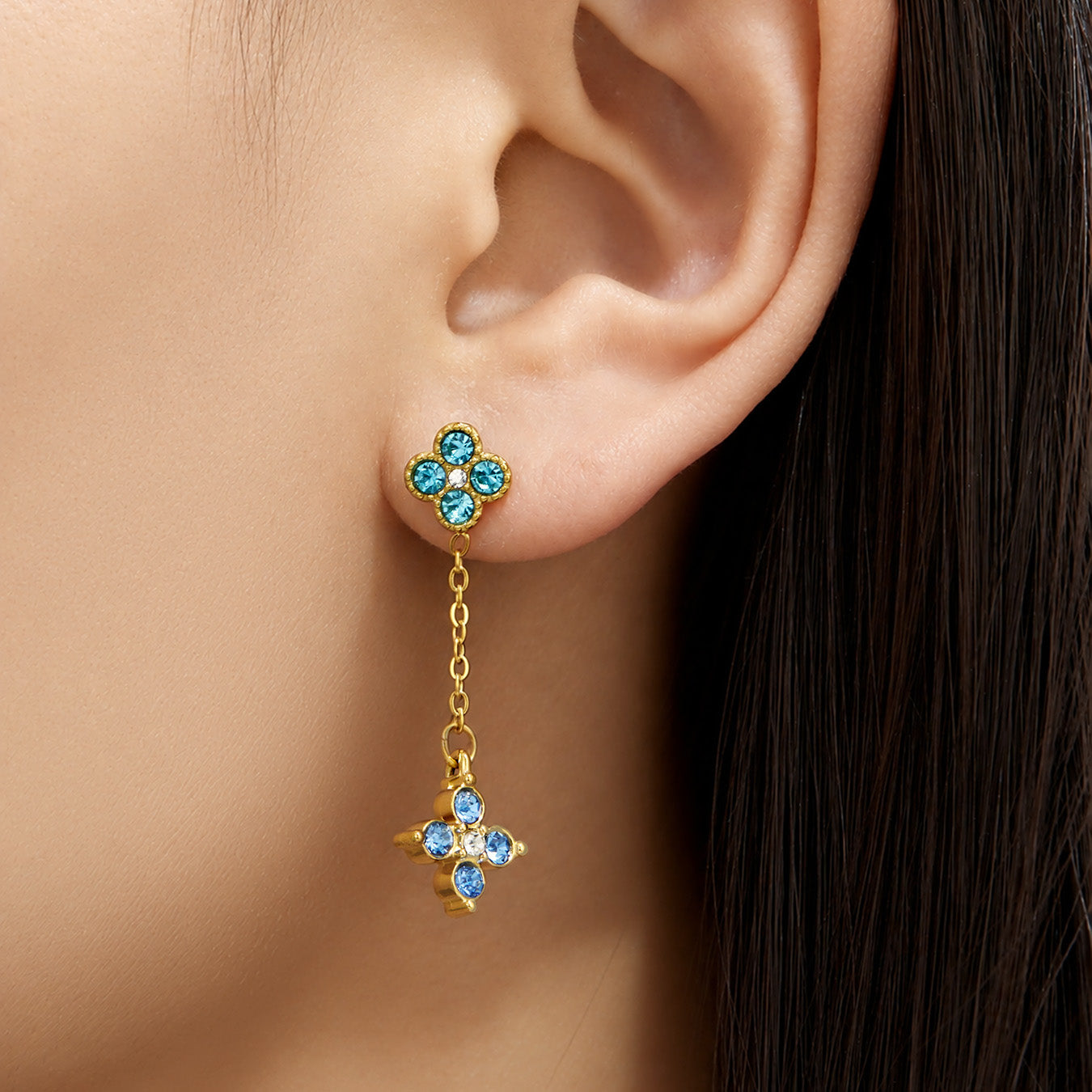 Model wearing blue cubic zirconia four-leaf clover drop earrings