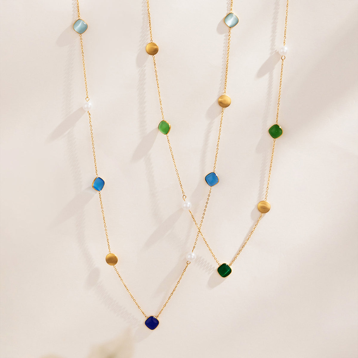 Gold-tone long necklaces with blue, green and warm-tone cat eye effect bead details