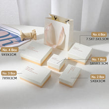 Boutique display of white and pink jewelry boxes for rings earrings necklaces and small jewelry pieces
