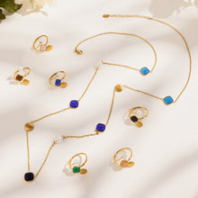 Gold-tone cat eye bead necklace and open ring collection arranged in a jewelry flat lay
