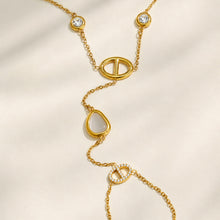 Close-up of white cat eye stones and geometric D-shaped links on a gold hand chain