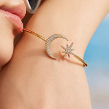 Close-up of a gold celestial cuff bracelet with star, moon and zircon accents