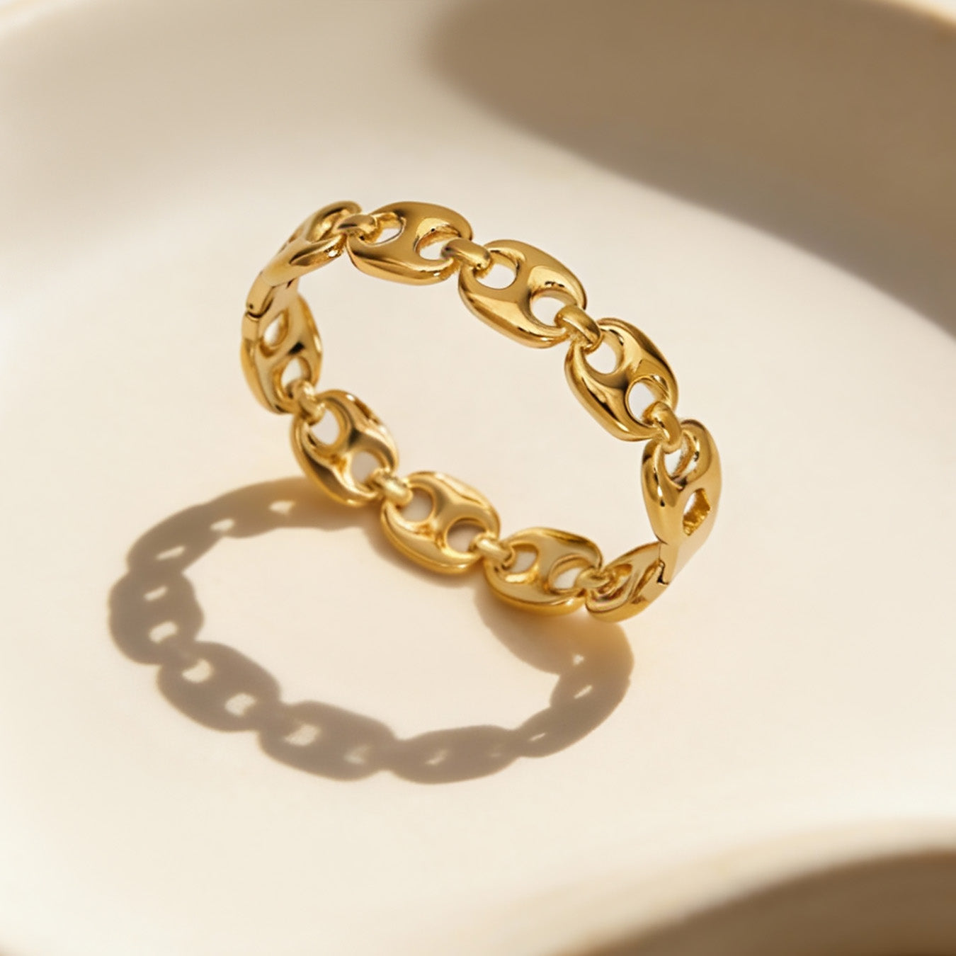 closeup of 18k gold chain link open bangle, hollow cutout stainless steel jewelry detail