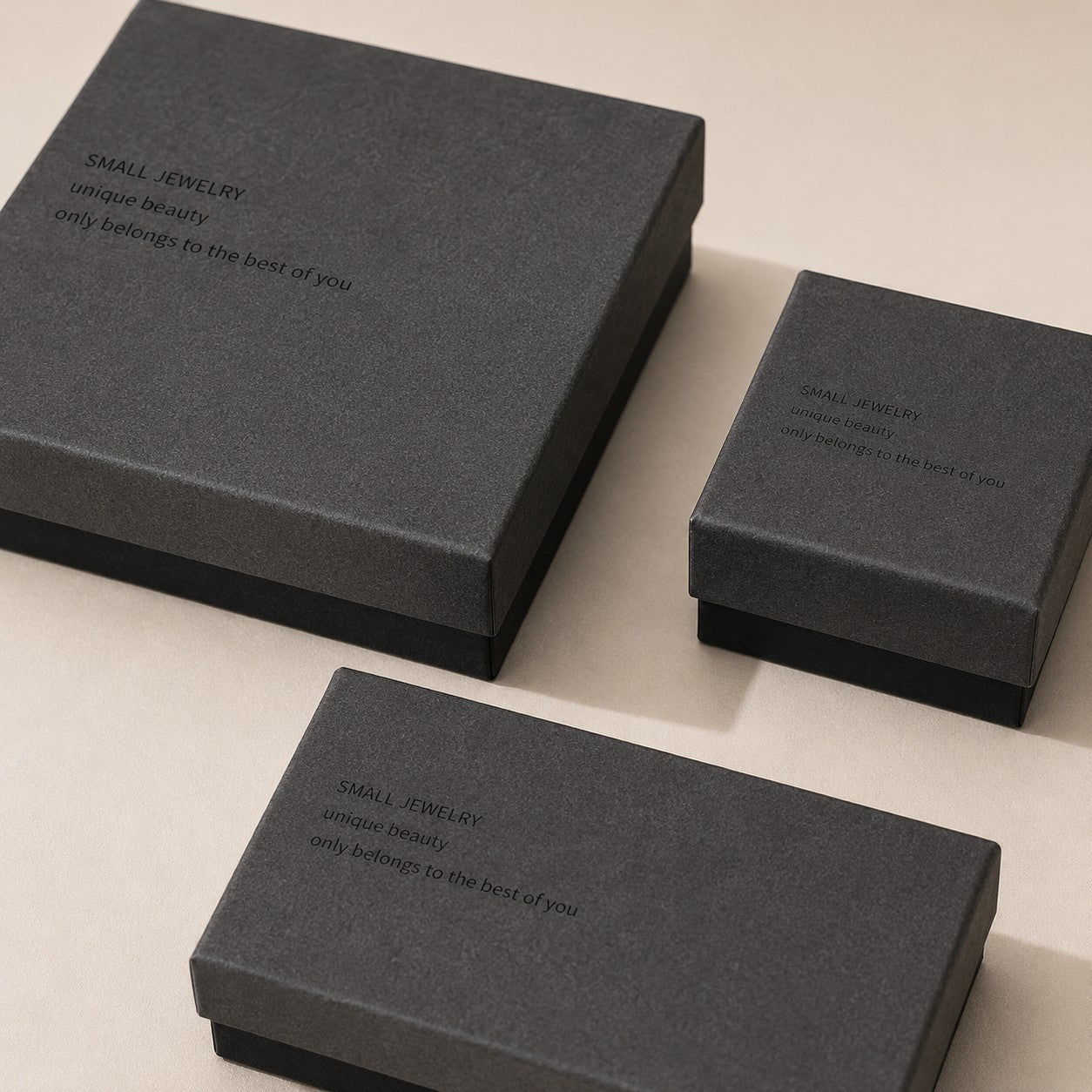 Close-up of charcoal gray jewelry boxes showing textured paper finish and black base