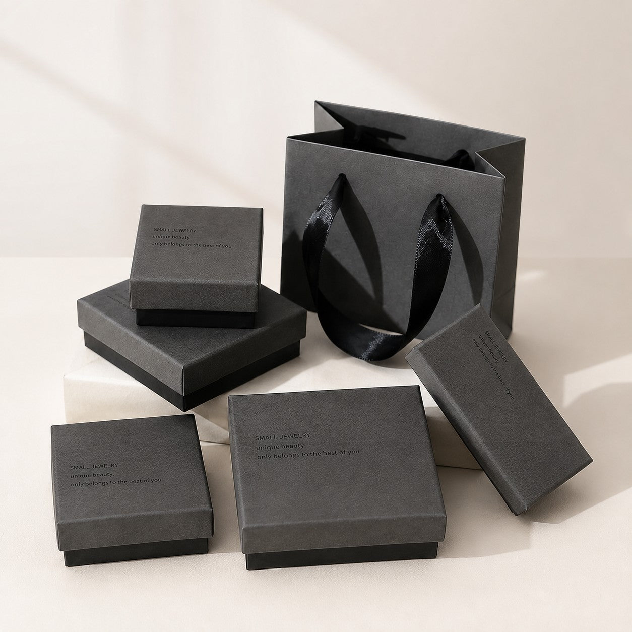 Charcoal jewelry boxes with black ribbon gift bag in a premium jewelry packaging display