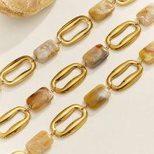 Close-up flat lay of oversized gold chain links and resin elements in the P689 statement necklace
