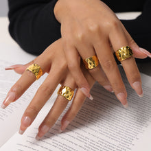 Chunky gold hammered rings styled on model with statement hand jewelry