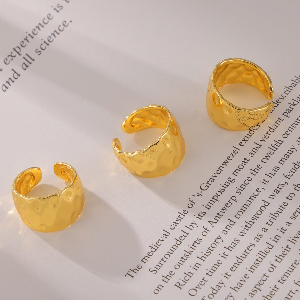 Chunky gold hammered open ring flat lay showing wide sculptural band