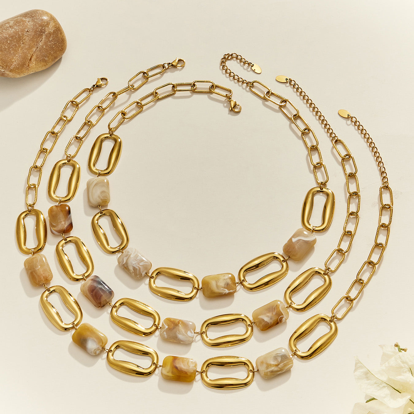 Chunky resin chain link necklaces arranged together in a layered flat lay for statement jewelry styling