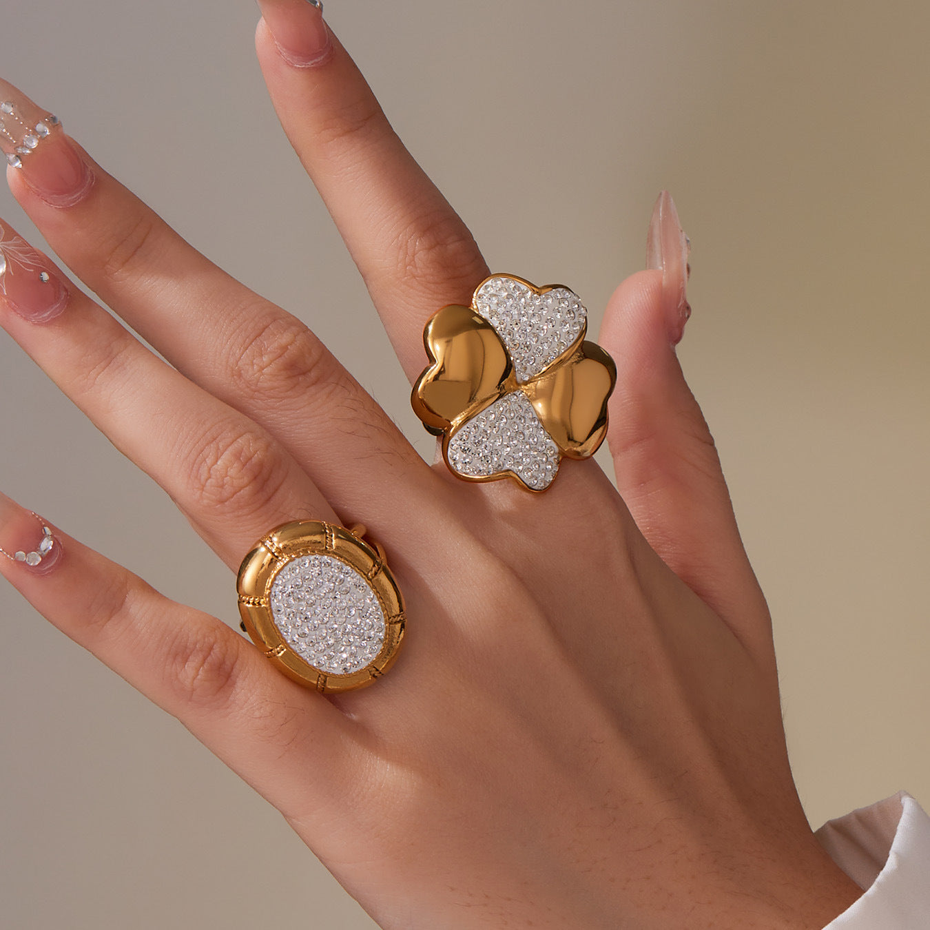 Model wearing a gold four-leaf clover statement ring with polished and pavé details