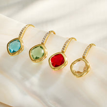 Colorful glass stone drop earrings arranged in a styled flat lay