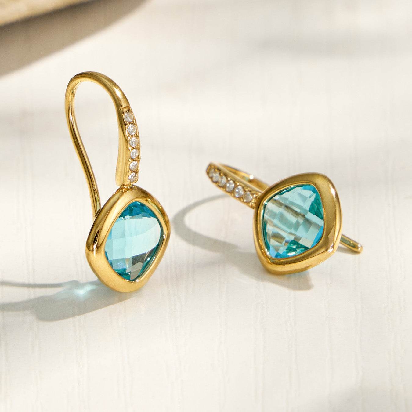 Colored glass stone drop earrings displayed in blue, green and red color options