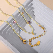 Colorful natural stone beaded necklaces with gold stainless steel chains arranged in a flat lay