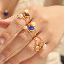 Colorful cat eye bead open rings in blue, brown and pink tones styled on model hand