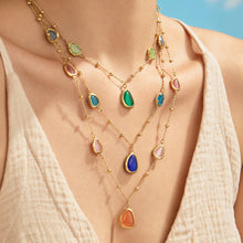 Colorful cat eye stone necklaces with geometric teardrop details styled on model