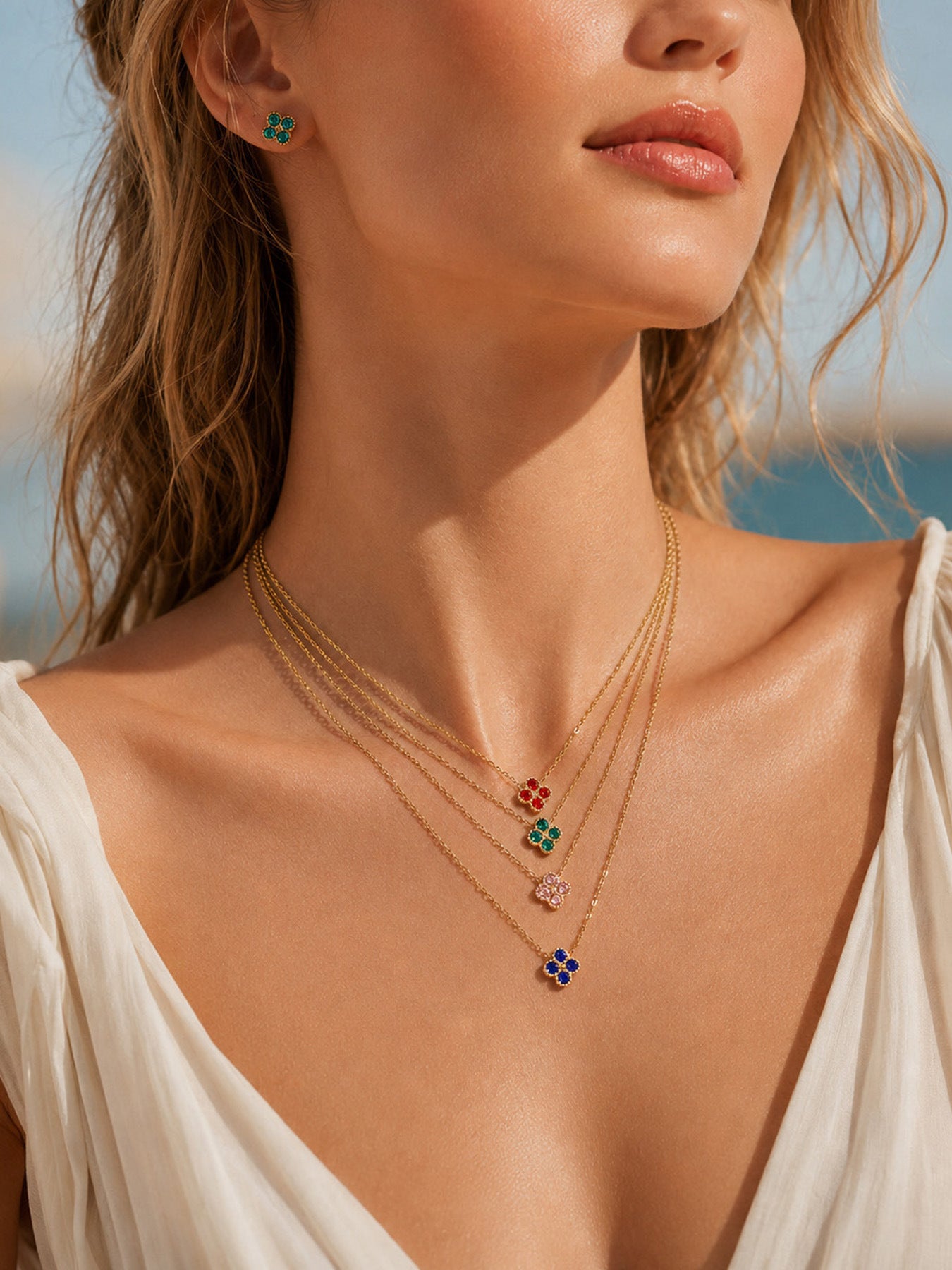 Close-up of model wearing layered colorful clover zircon necklace in gold tone stainless steel