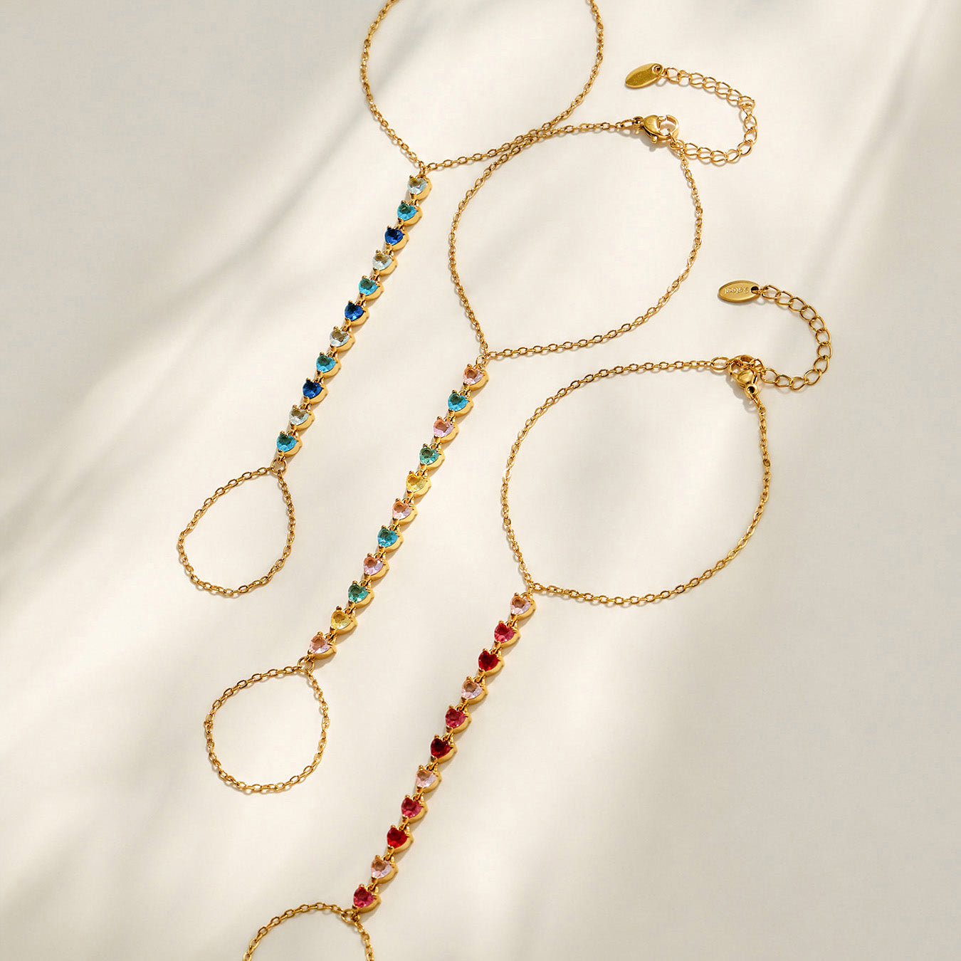 Colorful cubic zirconia hand chain bracelets displayed in multiple styles