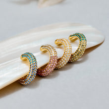 Colorful C-shaped ear cuffs arranged in a stacked jewelry display
