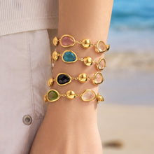 Colorful glass stone bracelets stacked on wrist