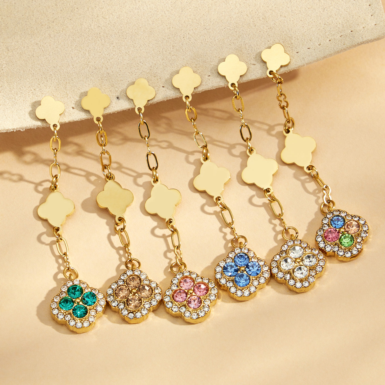 Colorful gold clover drop earrings arranged together on a jewelry display