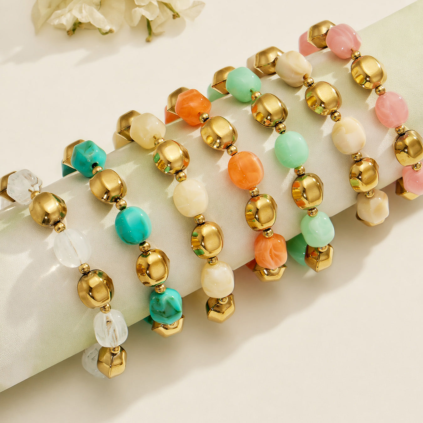Flat lay of colorful resin bead necklace and bracelet strands arranged in multiple coordinated colorways.
