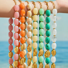 Colorful resin bead necklaces draped over an arm, showing seven colorways with gold-tone accents