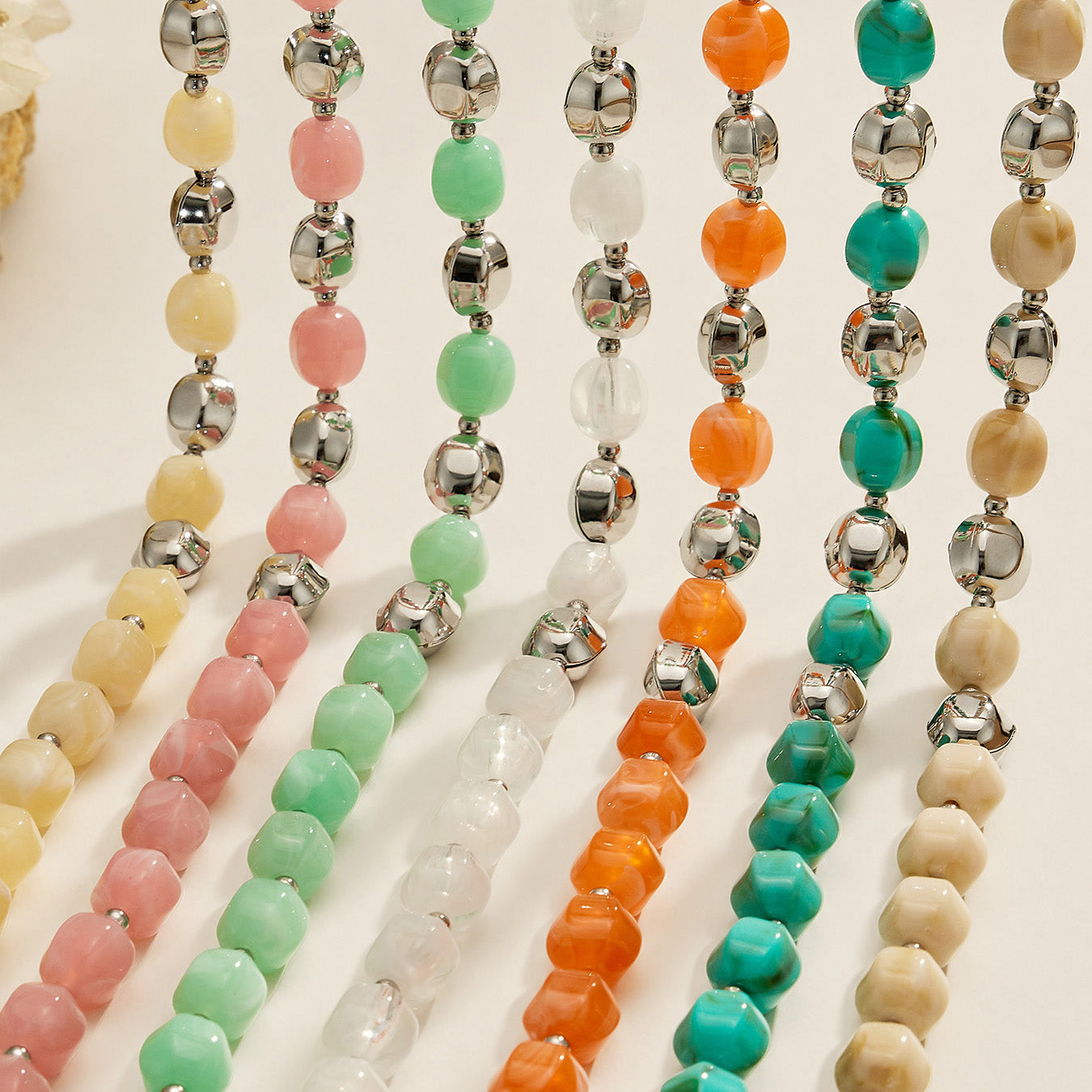 Display image of colorful resin bead jewelry strands arranged vertically in multiple colorways.