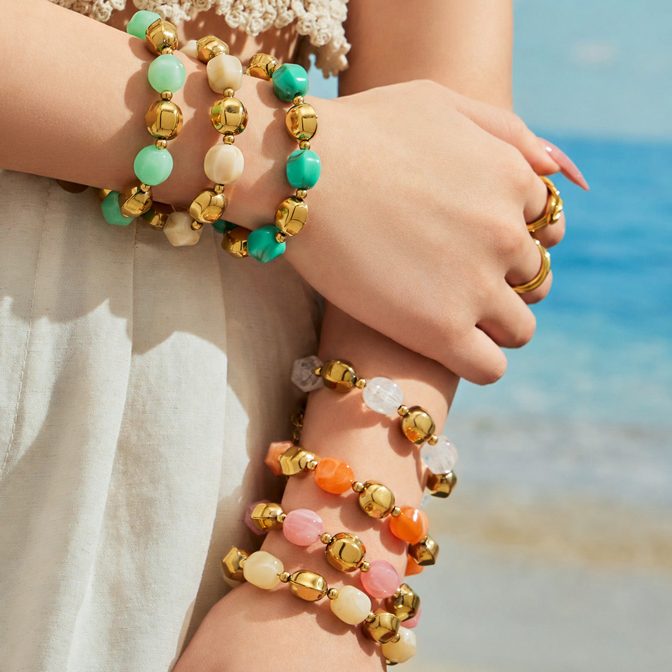 Close-up of stacked colorful resin bead bracelets with 316L stainless steel accents worn on the wrist.