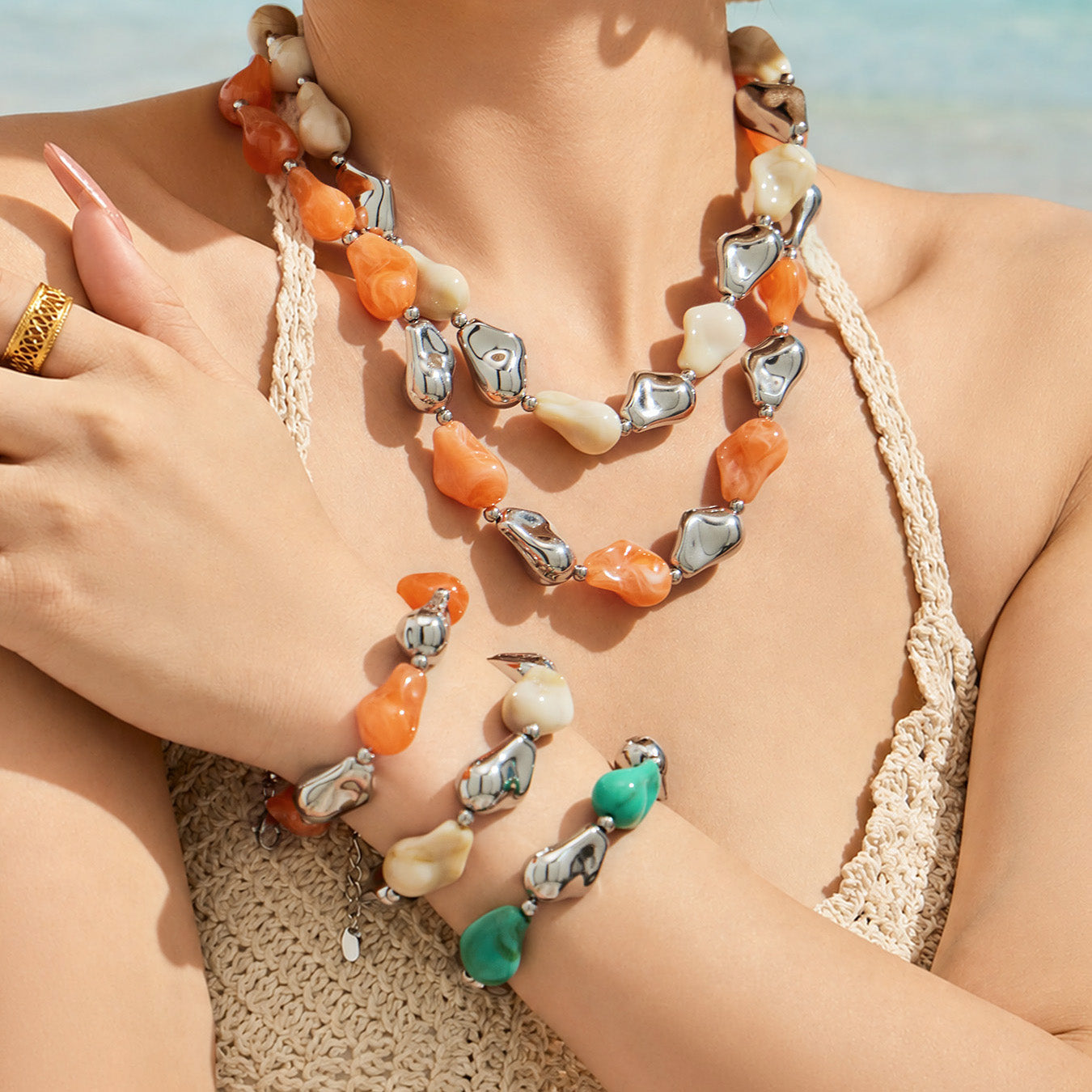 Model wearing a colorful chunky resin necklace and matching bracelet set with sculptural metal accents