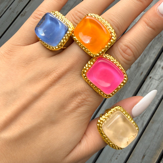 Blue orange pink and ivory resin statement rings worn on hand