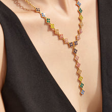 Torso view of a model wearing a colorful zircon lariat necklace