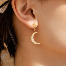 Side view of a model wearing a gold crescent moon celestial earring