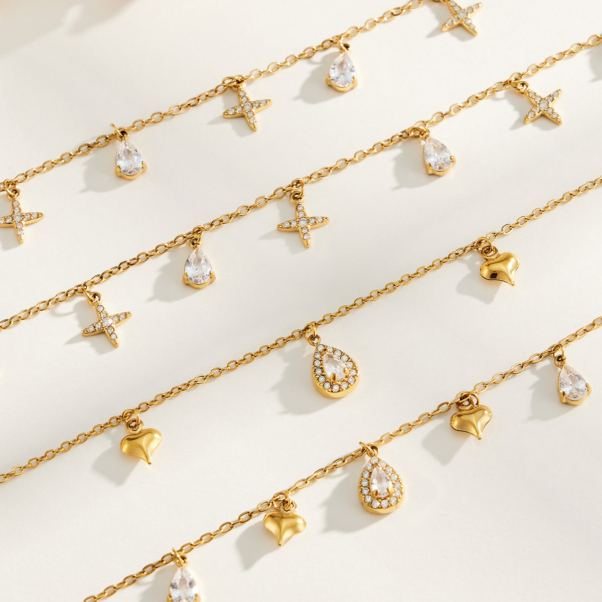 Gold-tone cross and heart charm jewelry with teardrop zircon details