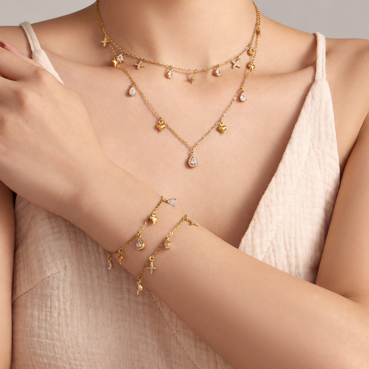 Dainty cross and teardrop zircon necklace and bracelet styled on model