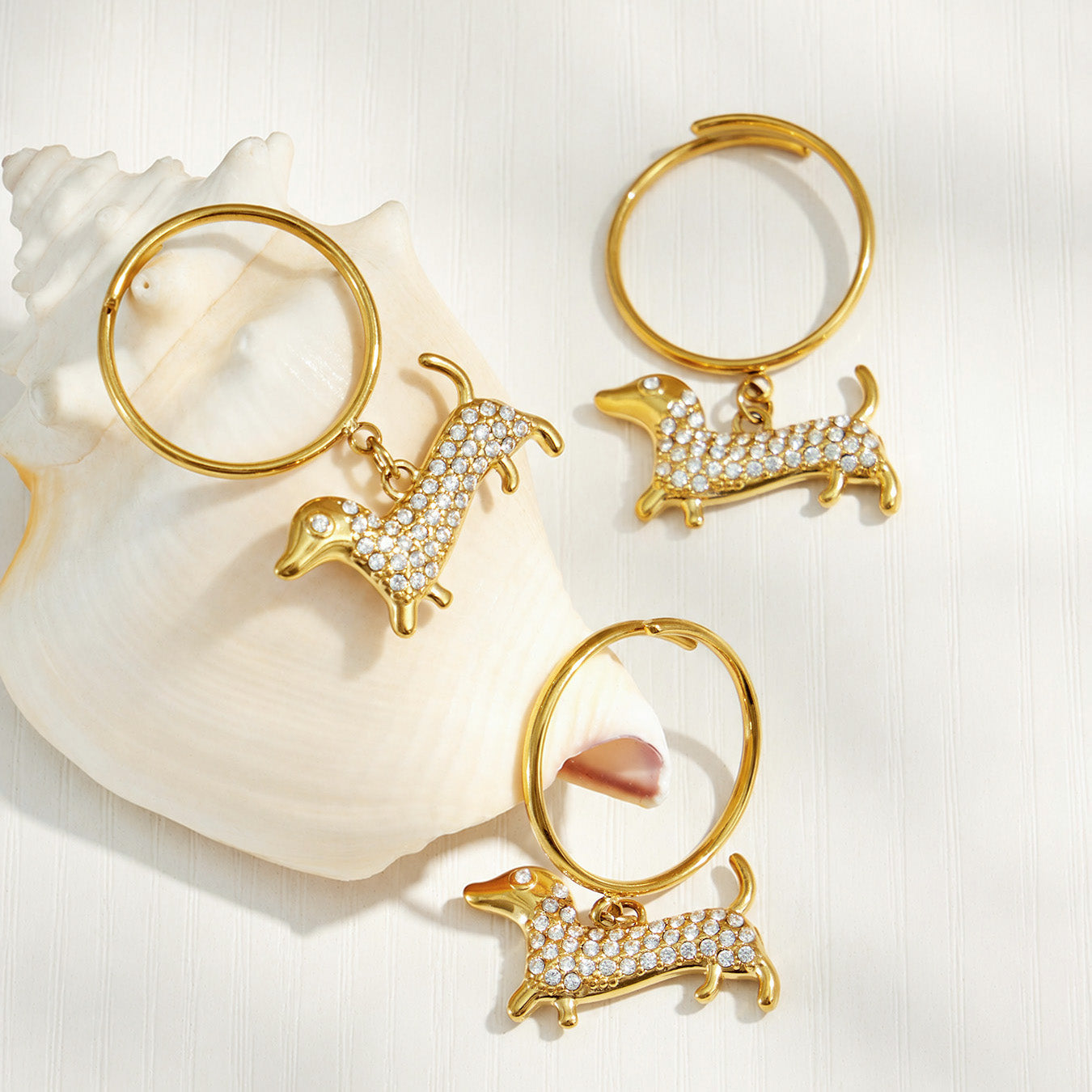 Model holding her hand near her face while wearing gold dachshund zircon rings
