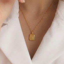 Woman wearing dainty 18K gold plated stainless steel "where is love" tag necklace with dual paperclip chain, elegant white shirt lifestyle shot