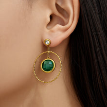 Model wearing dark green glass stone drop earrings with gold twisted hoop