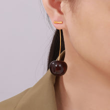 Model wearing deep red gradient cherry dangle earrings with long stems