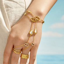 Front view of a gold-tone wrist-to-finger bracelet connected to two finger loops