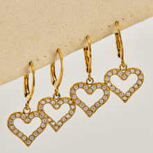 Multiple pairs of double heart drop earrings displayed in gold