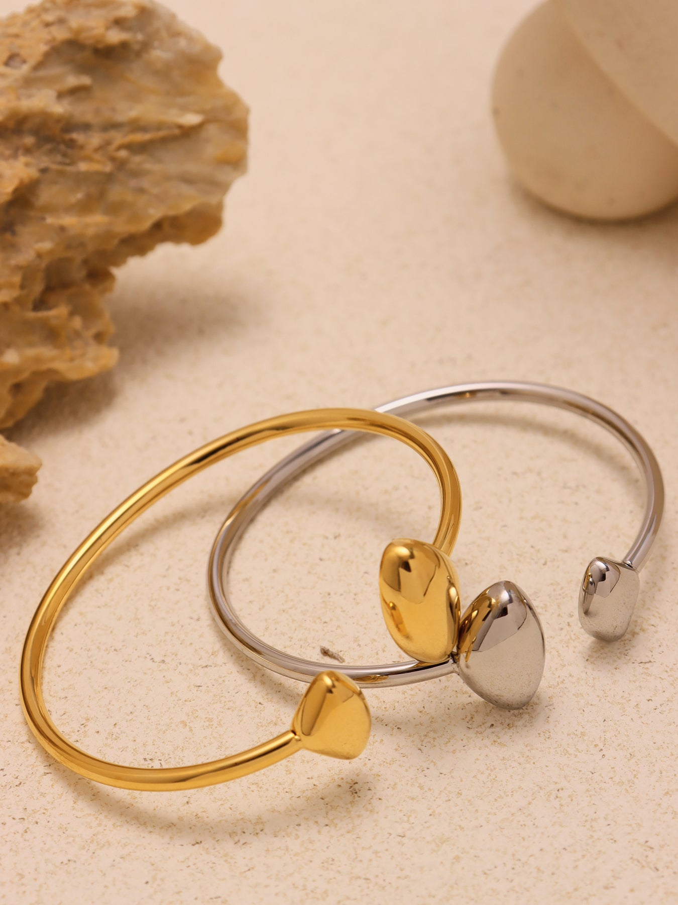 double heart open bangle scene daily - gold and silver heart bangles displayed on fabric