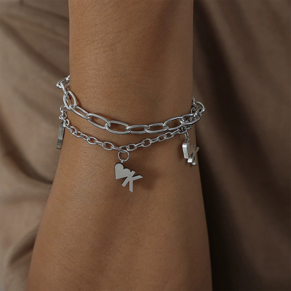 Close-up of double-layer heart chain bracelet in stainless steel with minimalist unisex styling