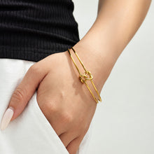 Double wire knot cuff bracelet with open ends styled on hand