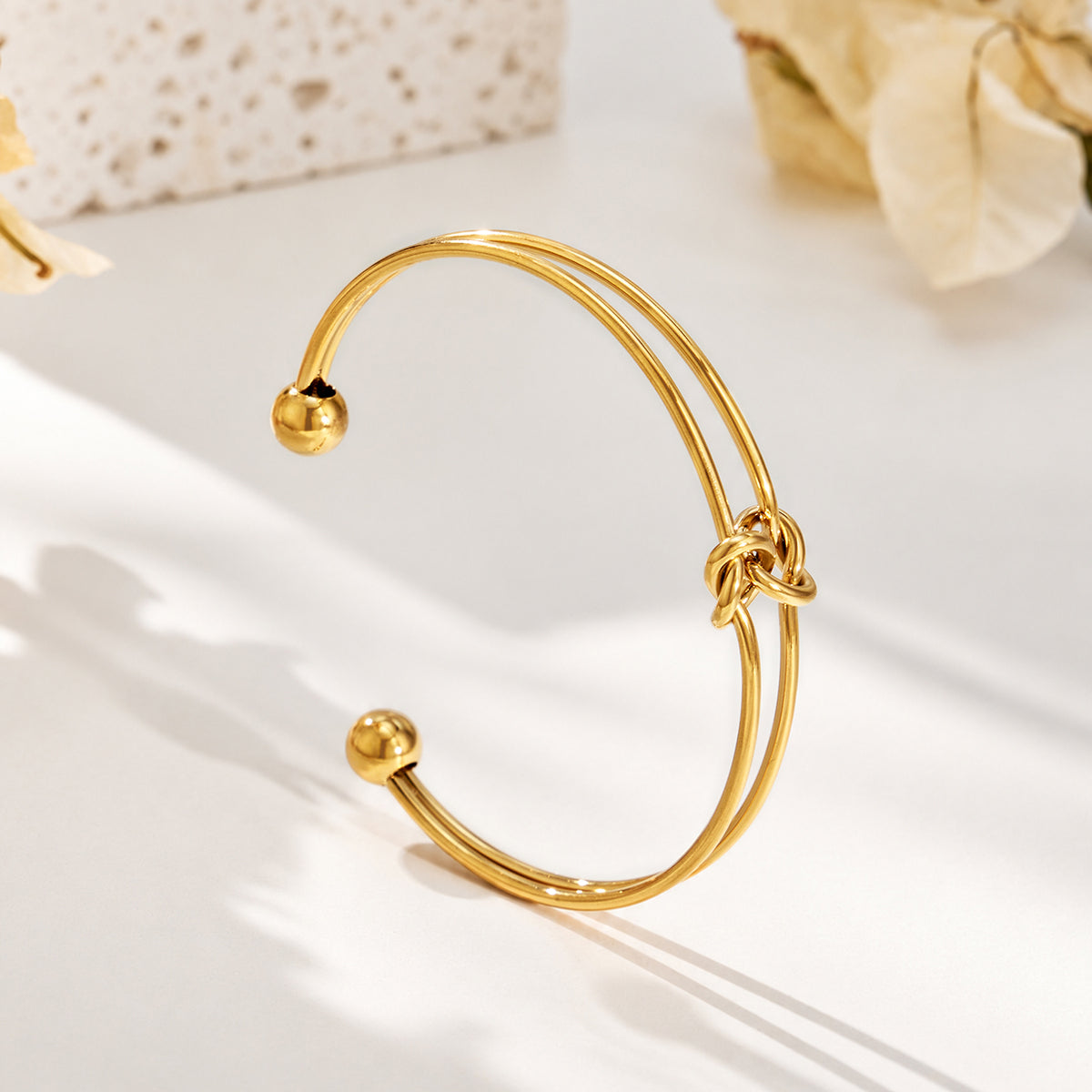 Stainless steel double wire open bangle with central knot detail