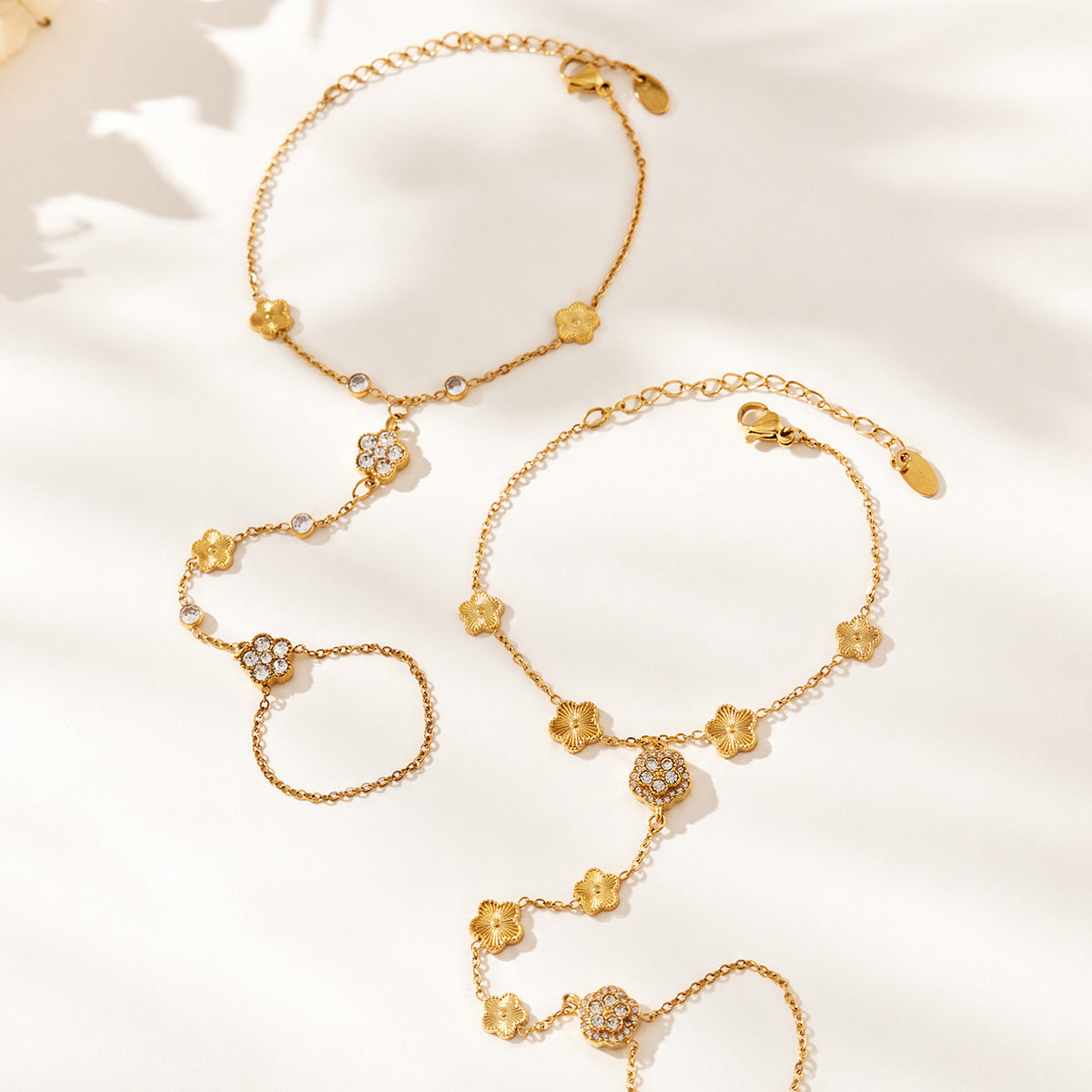 E304 gold-tone flower hand chain bracelets with ring-connected designs displayed together