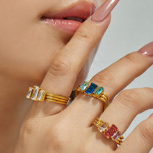Close-up of colorful emerald-cut CZ rings styled on a model hand
