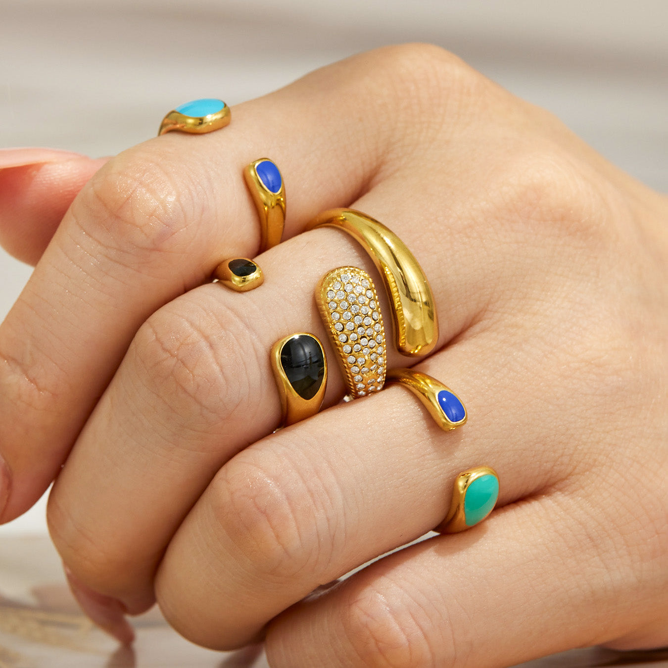 Flat lay of 316L stainless steel enamel open rings and pavé cubic zirconia open rings in gold finish