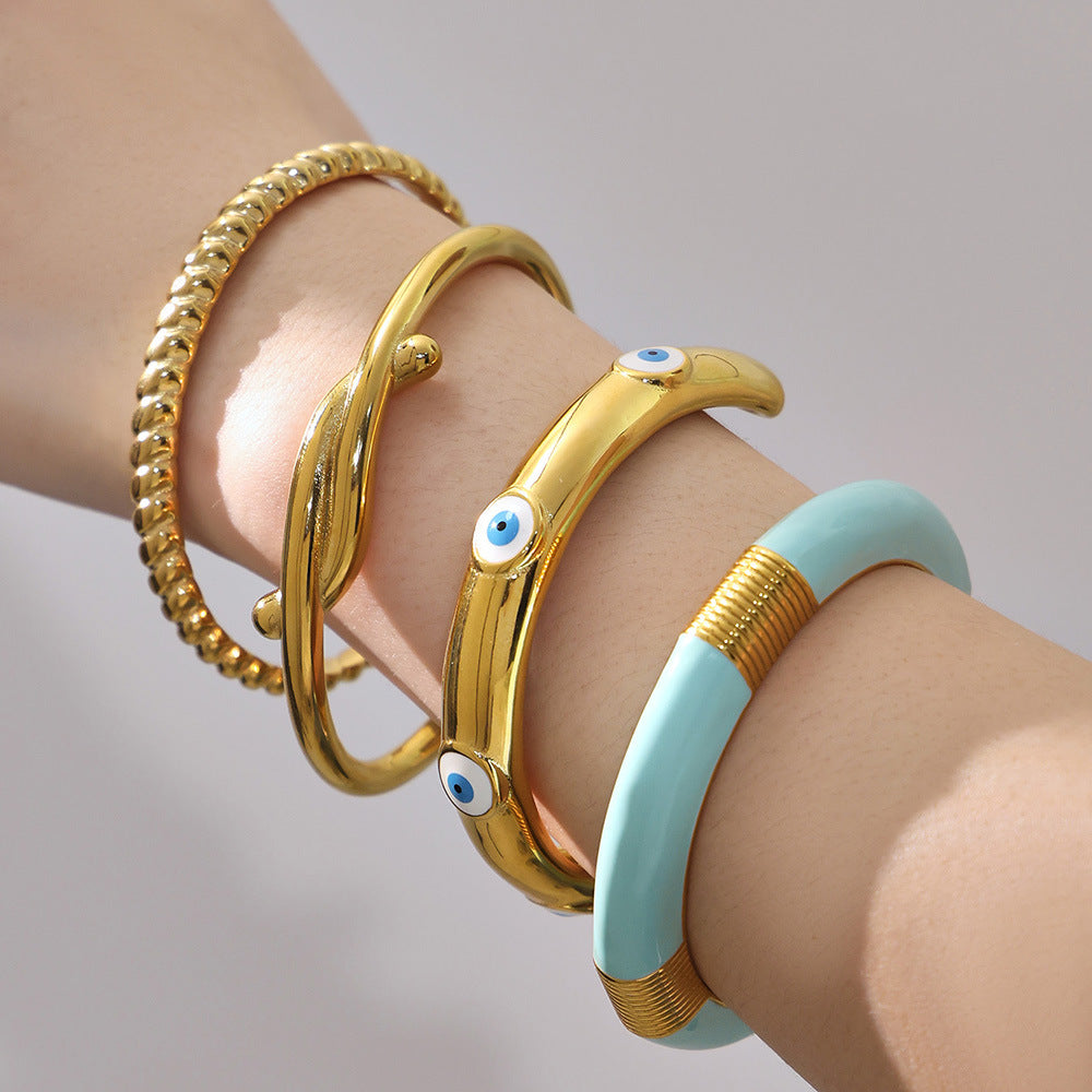 18k gold enamel stainless steel bangle set, layered on model's wrist